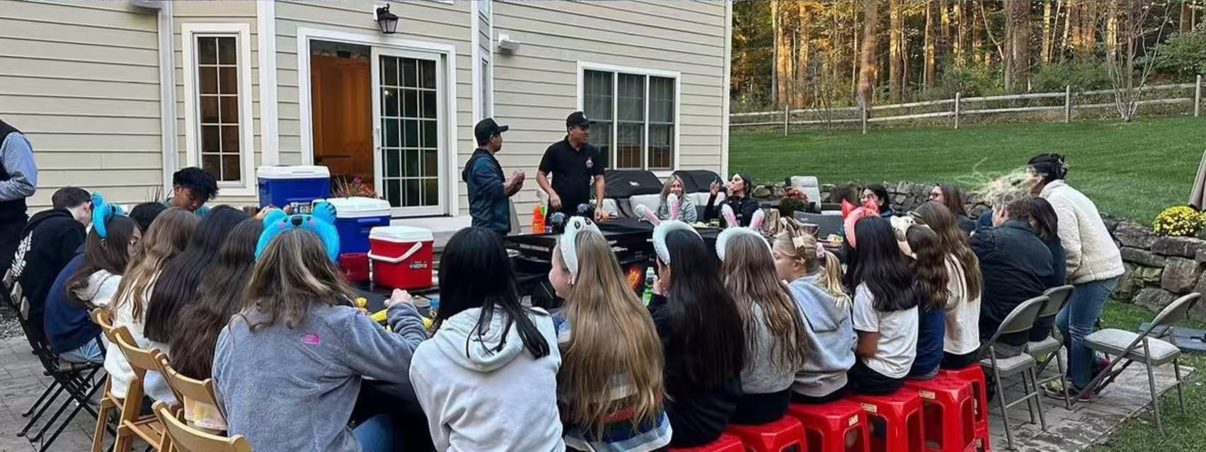 Hibachi chefs presenting the show to a group of guests