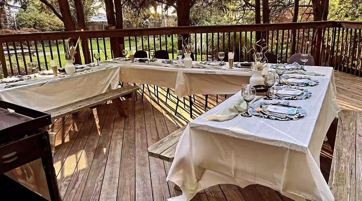 Wooden deck set up with U-shaped tables for a hibachi party