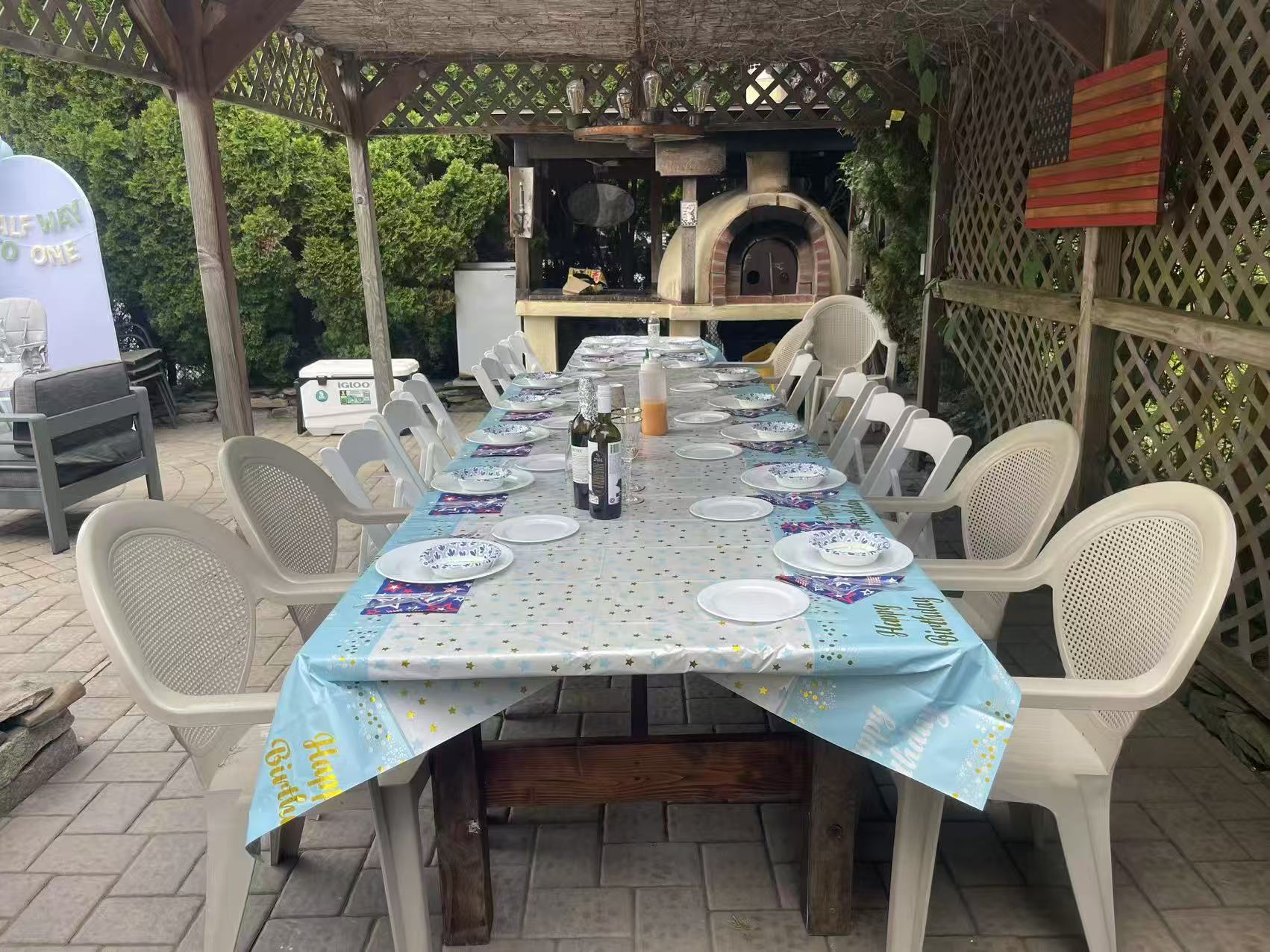 Long table set for a birthday party under a pergola